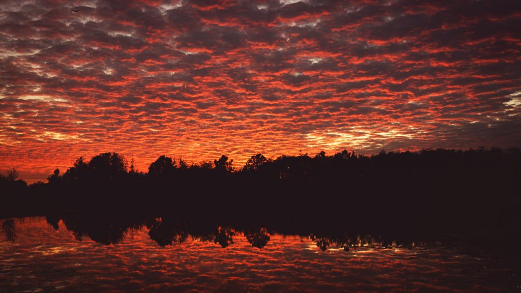 Sunset with dramatic clouds reflecting in lake