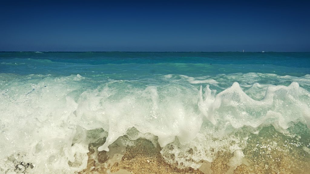 close view of waves crashing on beach